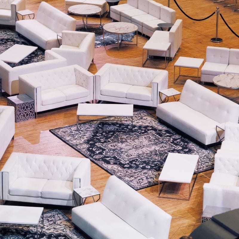 Convention Center Floor Lounge Set Up with White Couches and Gray Rugs